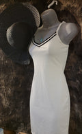 Small white sundress with black trim,  black straw sun hat and a light blue crystal necklace.